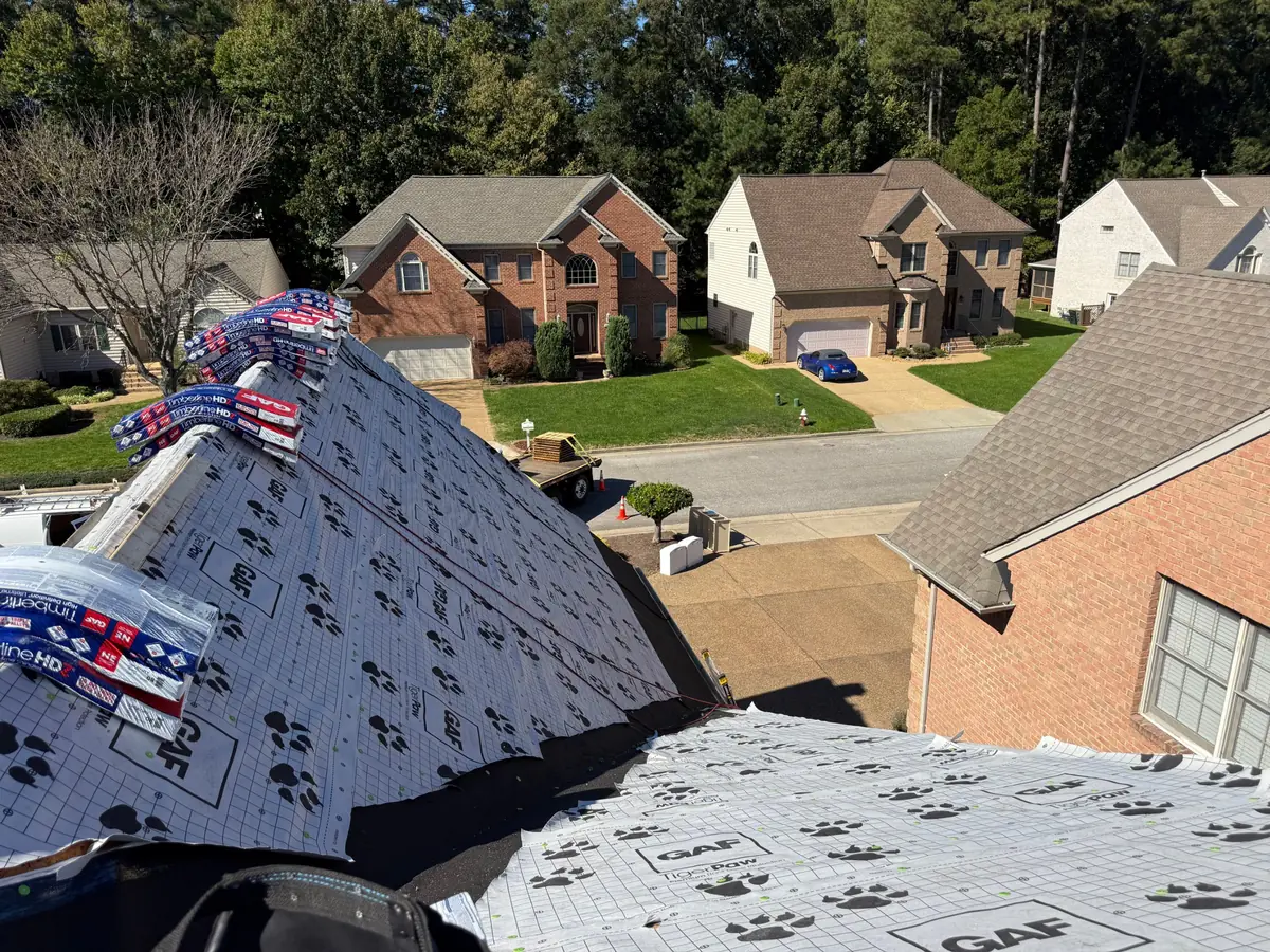Roof covered in GAF TigerPaw underlayment with Timberline HDZ shingle bundles staged along the ridge