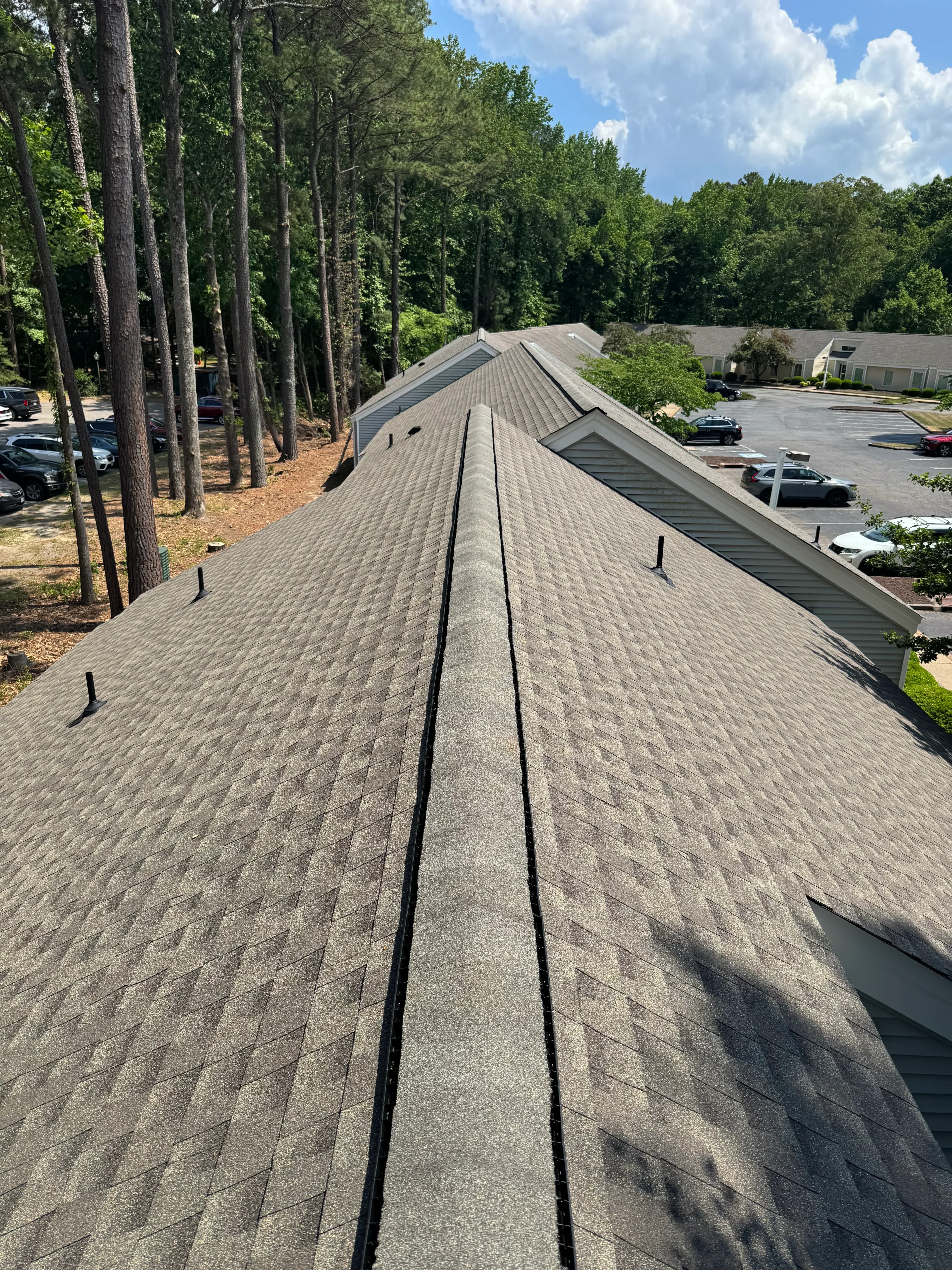 Gray architectural shingles with black flashing and new gutter system on residential roof